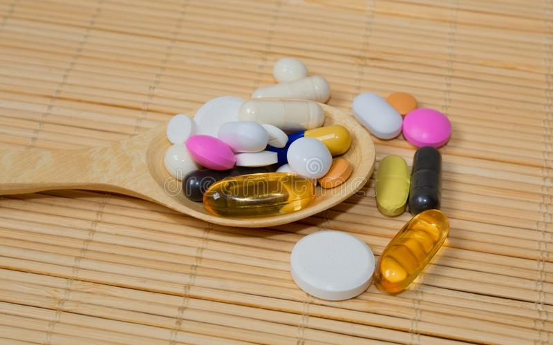 assortment pharmaceutical preparations wooden spoons tablets capsules bamboo mat assortment pharmaceutical 122576331